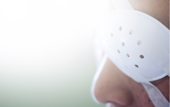 A close-up view of a person wearing an eye shield as they are currently recovering from eye surgery