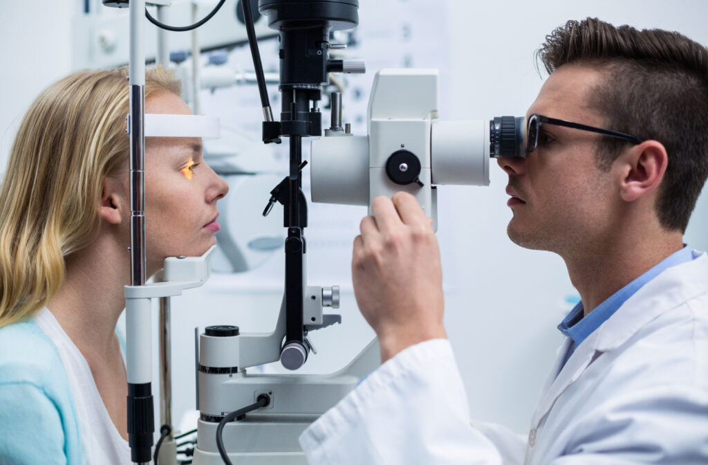 A woman receives an eye exam from a male optometrist