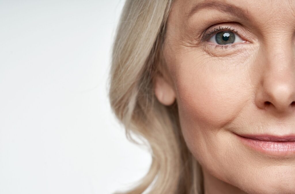 Close-up of the right side of a person's face as they smile and look into the camera with clear vision after ICL surgery.