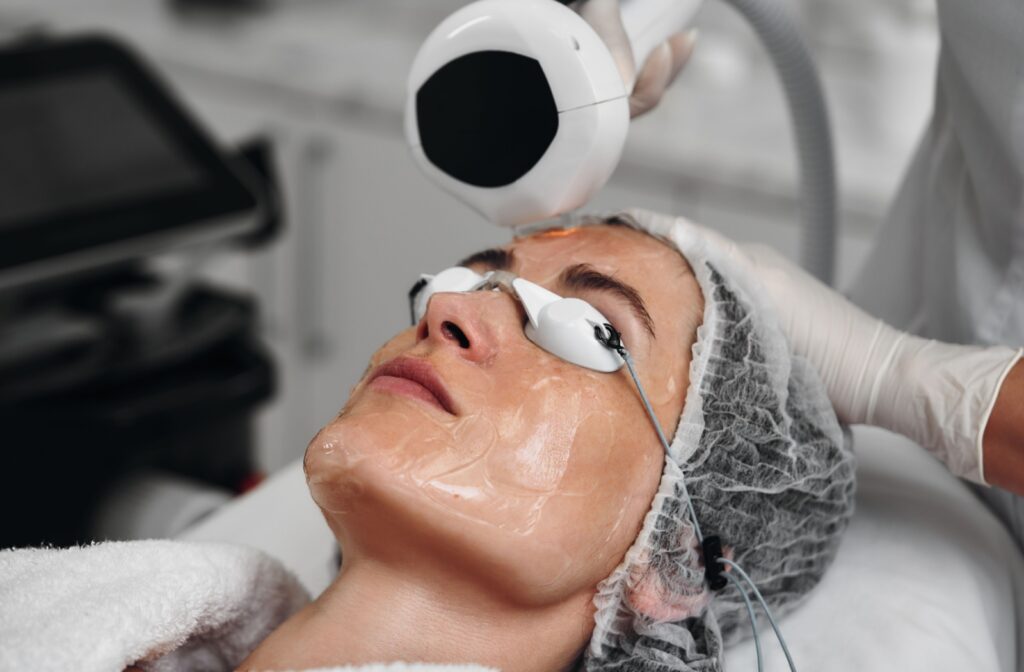 A patient with protective eye goggles and soothing gel undergoes IPL therapy for dry eyes.